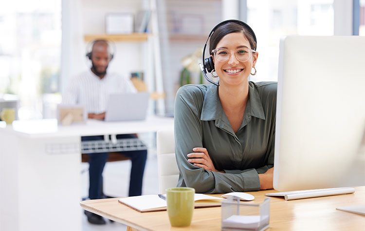 Eine Sales Managerin mit Headset sitzt vor ihrem Computerbildschirm